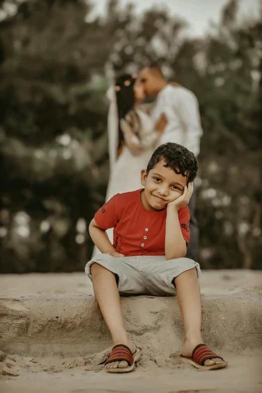 a small child sits near his parents as he poses for the camera