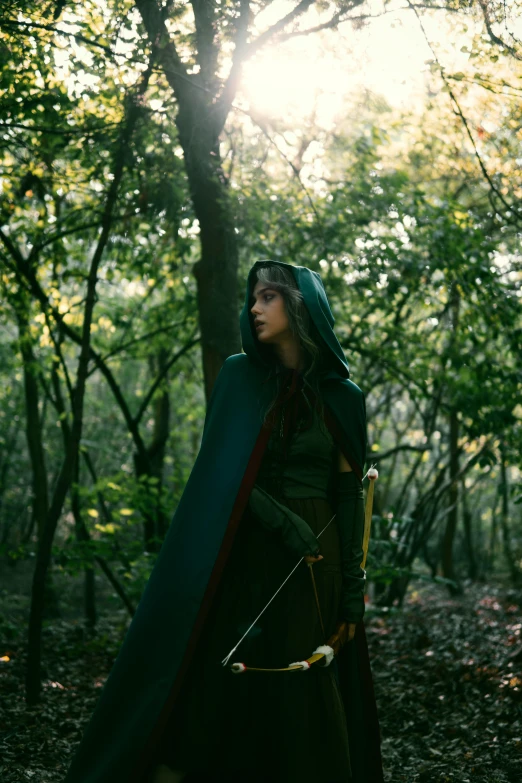 an attractive woman dressed in medieval clothing holding a bow