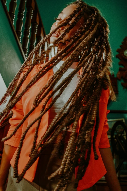 a woman with dread locks in her hair standing in a room