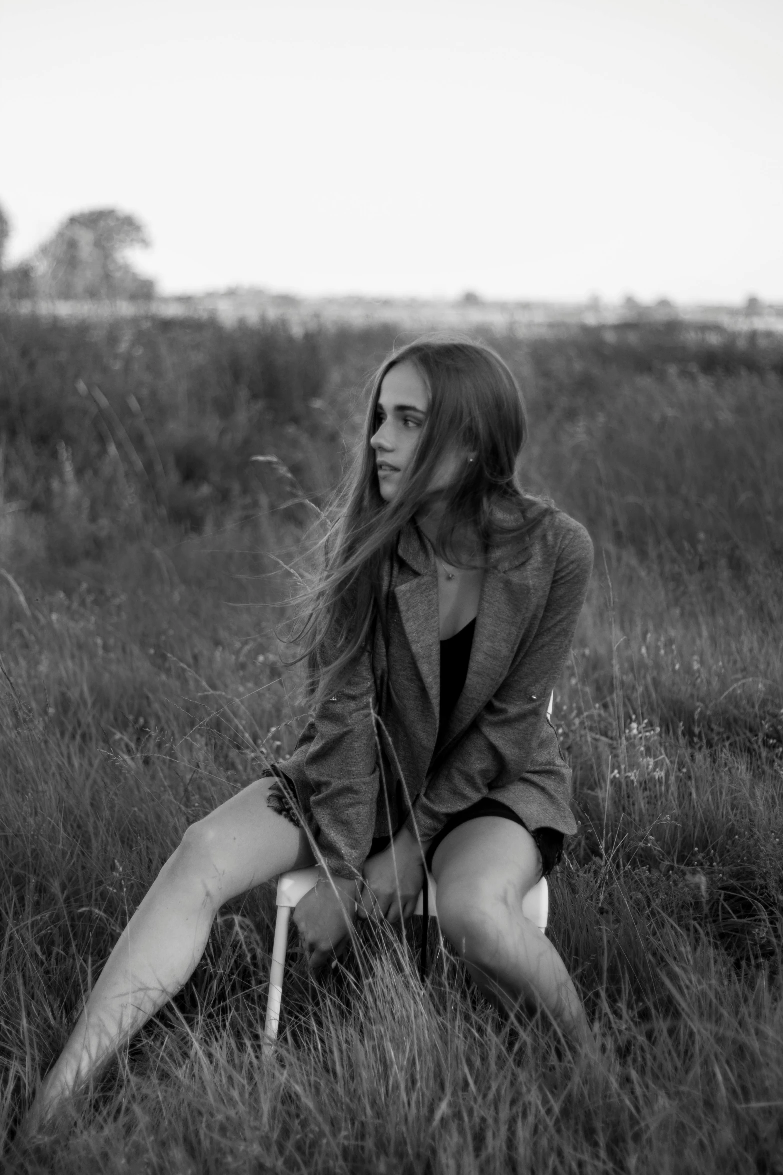 a woman in a grassy field posing for a black and white po