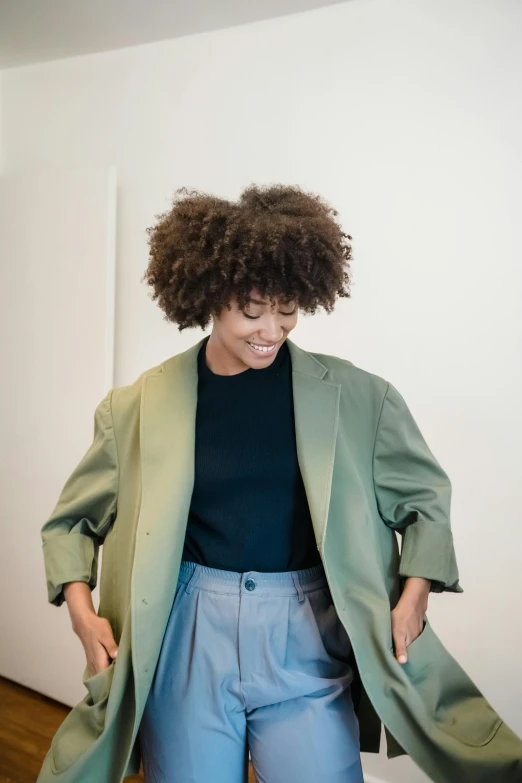 a woman in a green jacket and blue pants