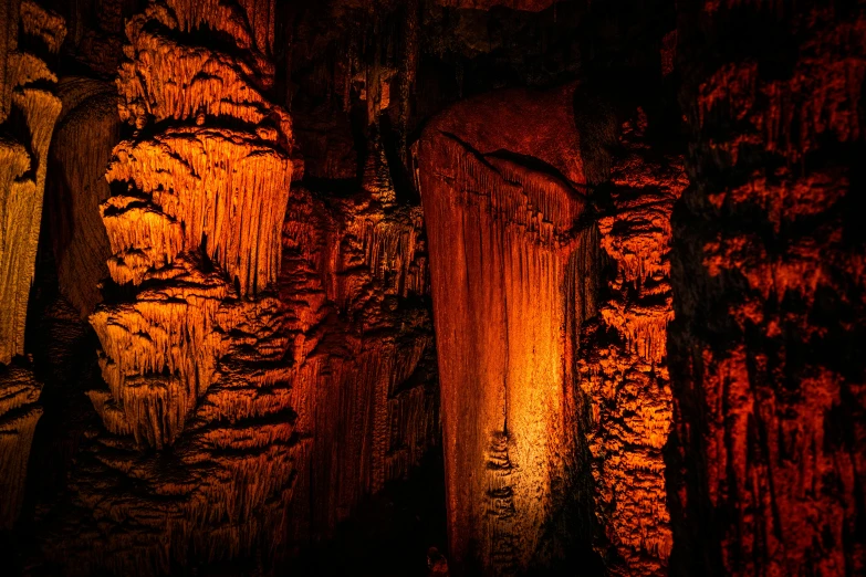 two lit candles in a cave on a red and orange background