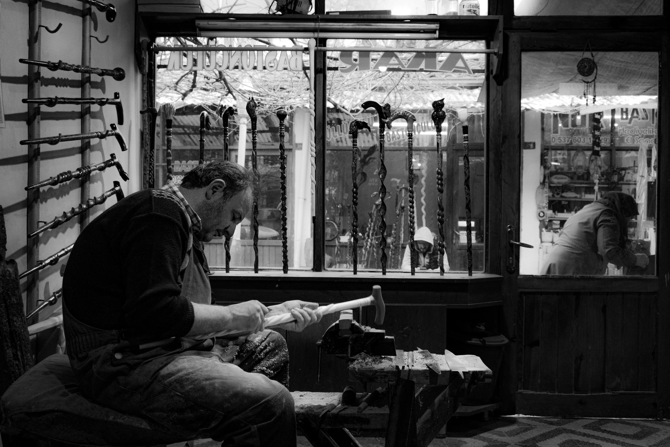 a man points at his shop in a window