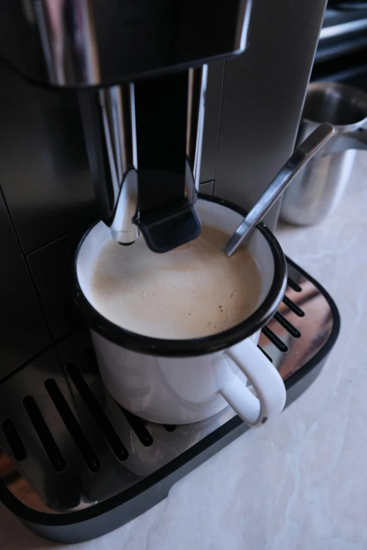 coffee is being poured into a cup in a coffee maker