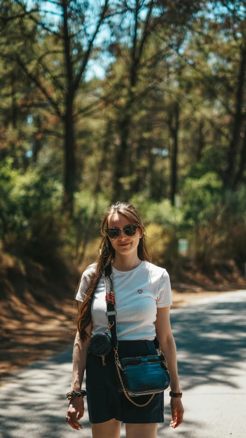 girl with sunglasses posing with a backpack on a street