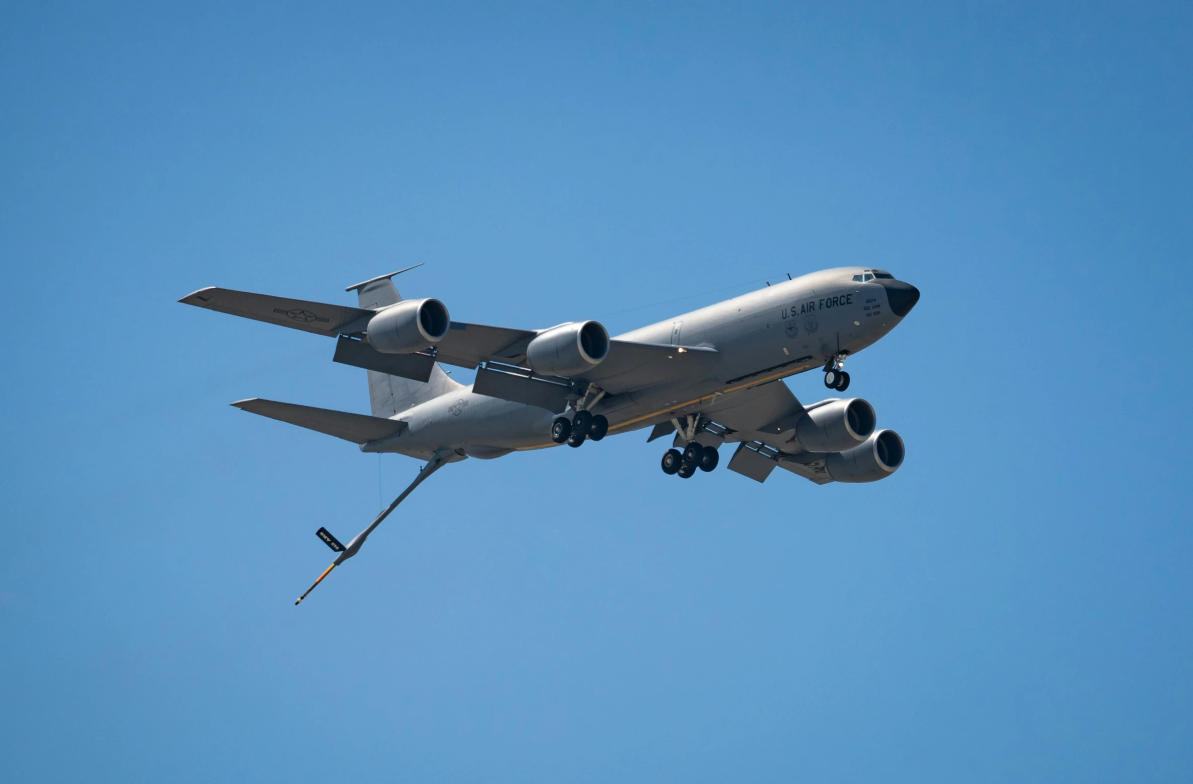 a plane with some wheels down flying in the sky