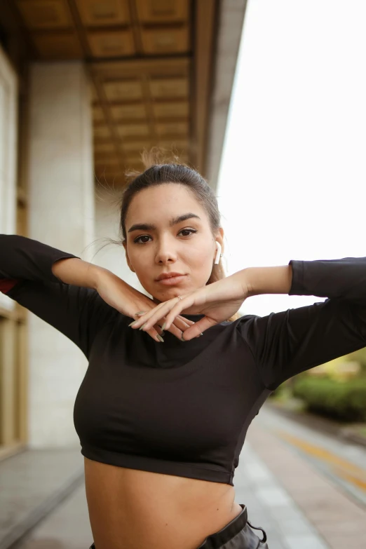 the young woman is posing near a building