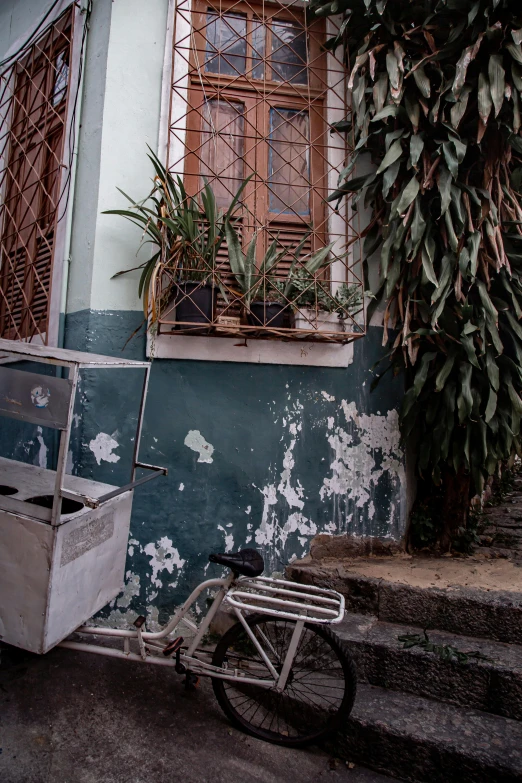 a bicycle leaning against a wall with a window