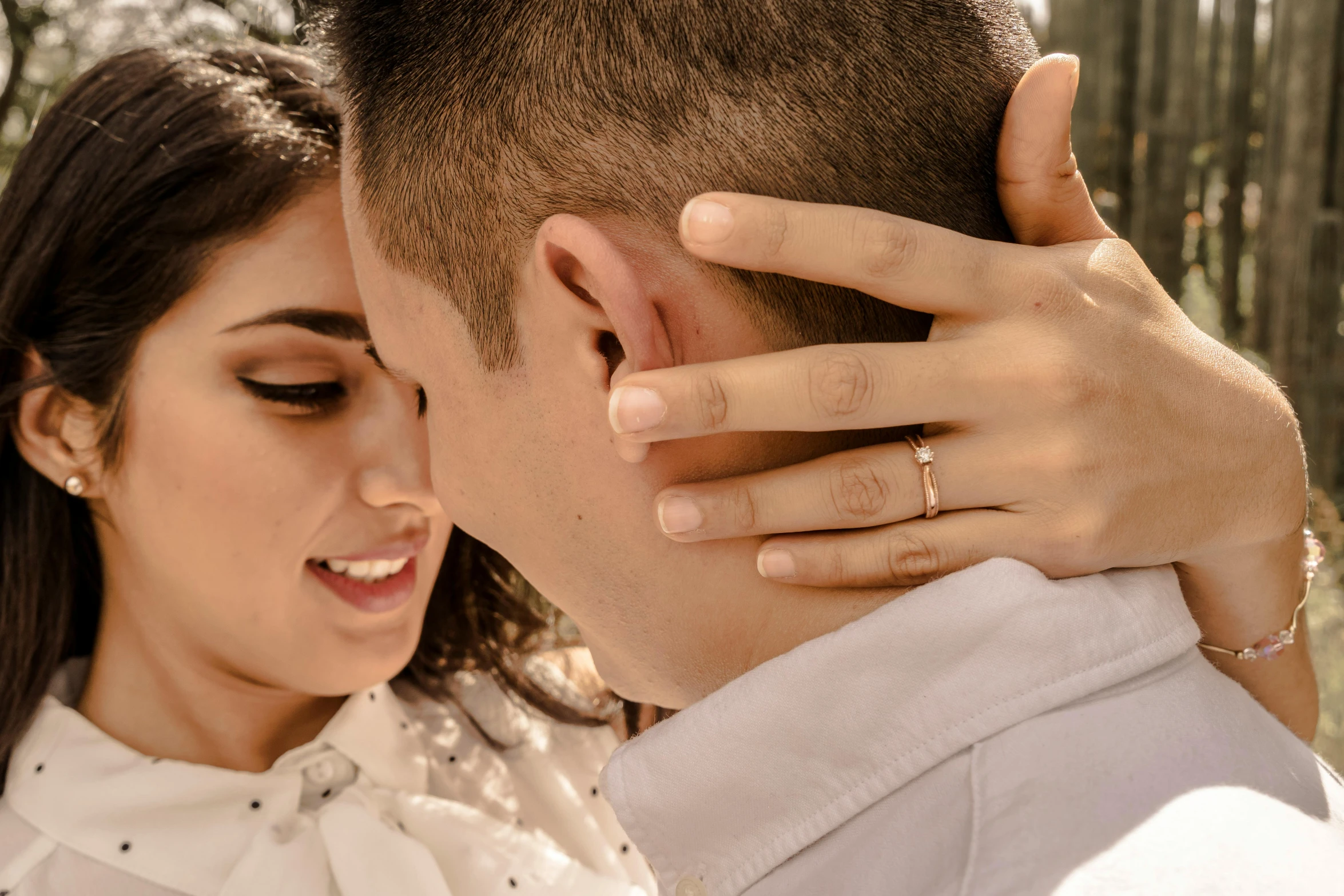 a young woman putting a ring on the forehead of a man