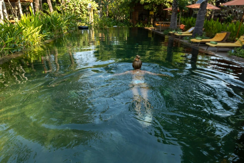 a person in a pool on the edge of some water