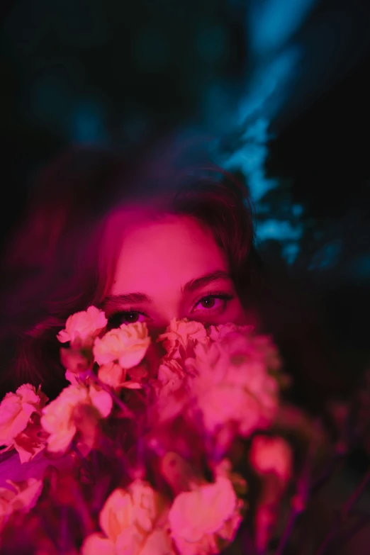 a woman hiding behind some flowers in the dark