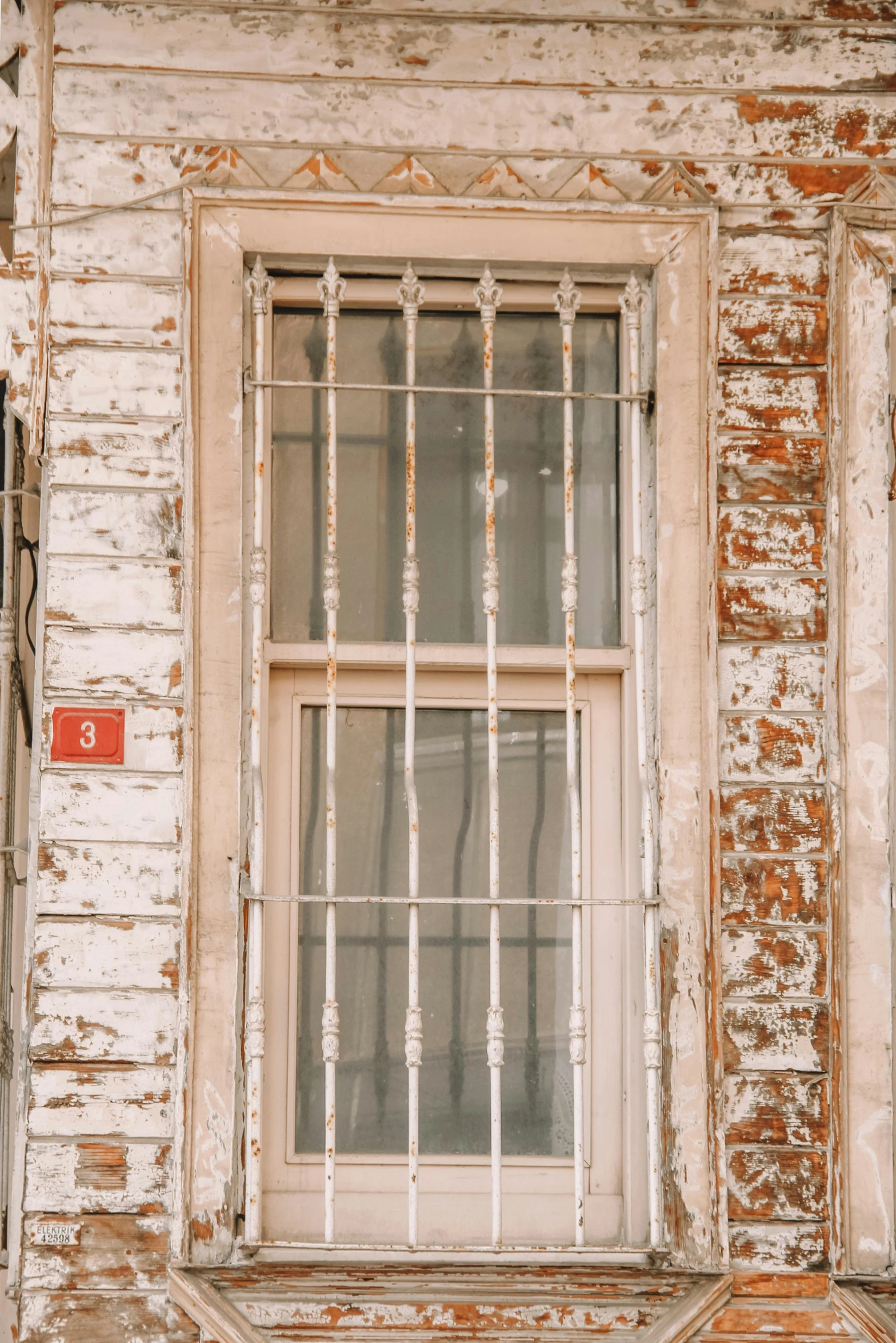 a building with barred windows and rusted bars