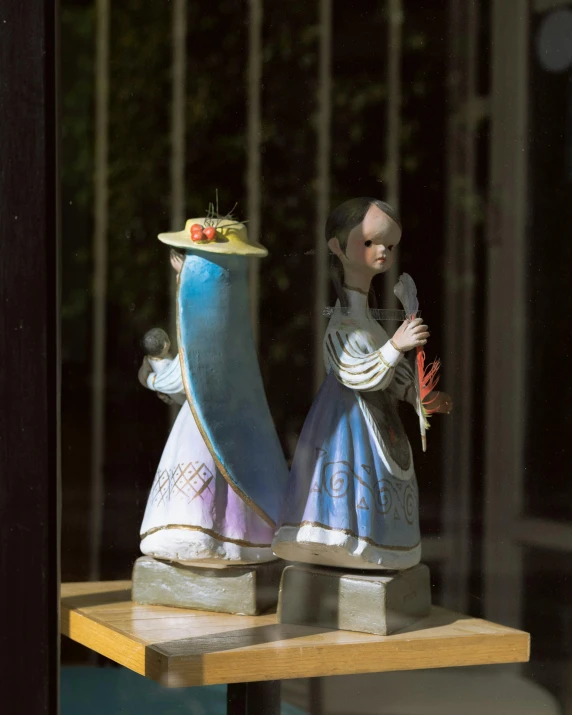 two decorative figures are shown on top of a table