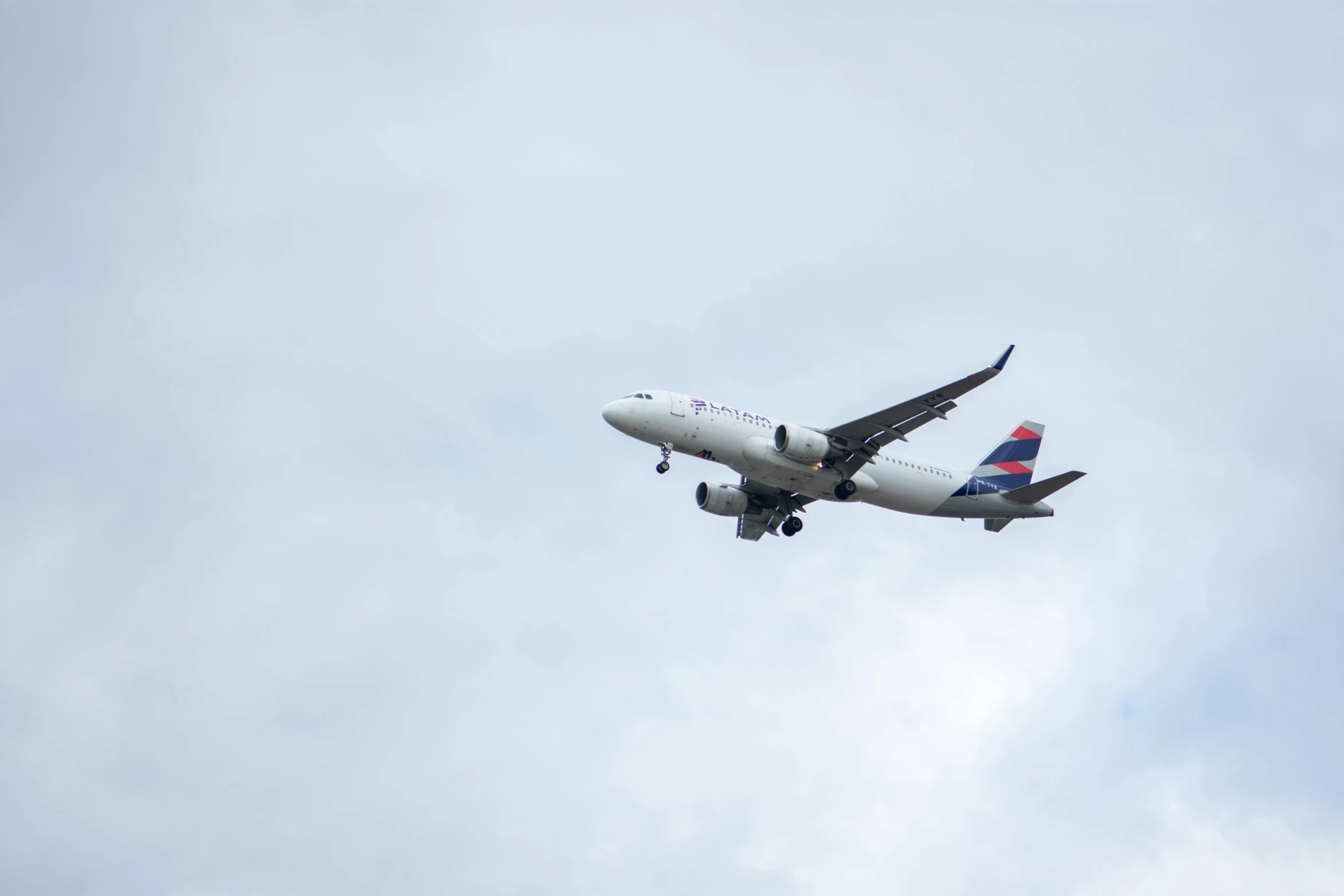 a large jetliner flying through a cloudy blue sky