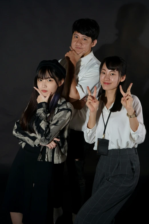 three people posing for a po with their hands in the air