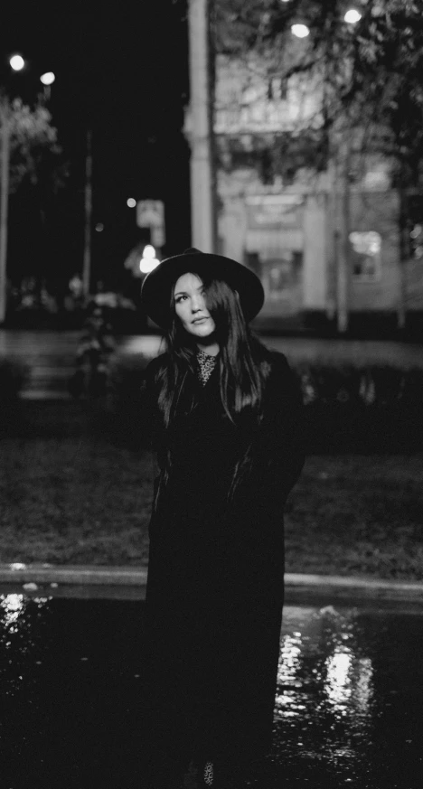 a woman in black is standing under the umbrella