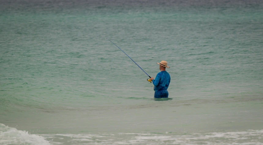 a person in the water holding a pole while fishing