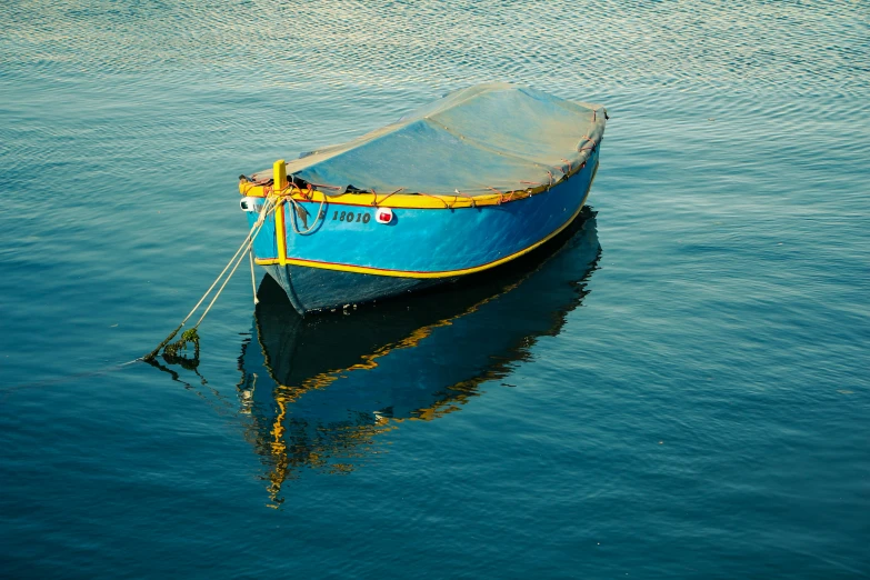 a boat that is blue and yellow sitting in the water