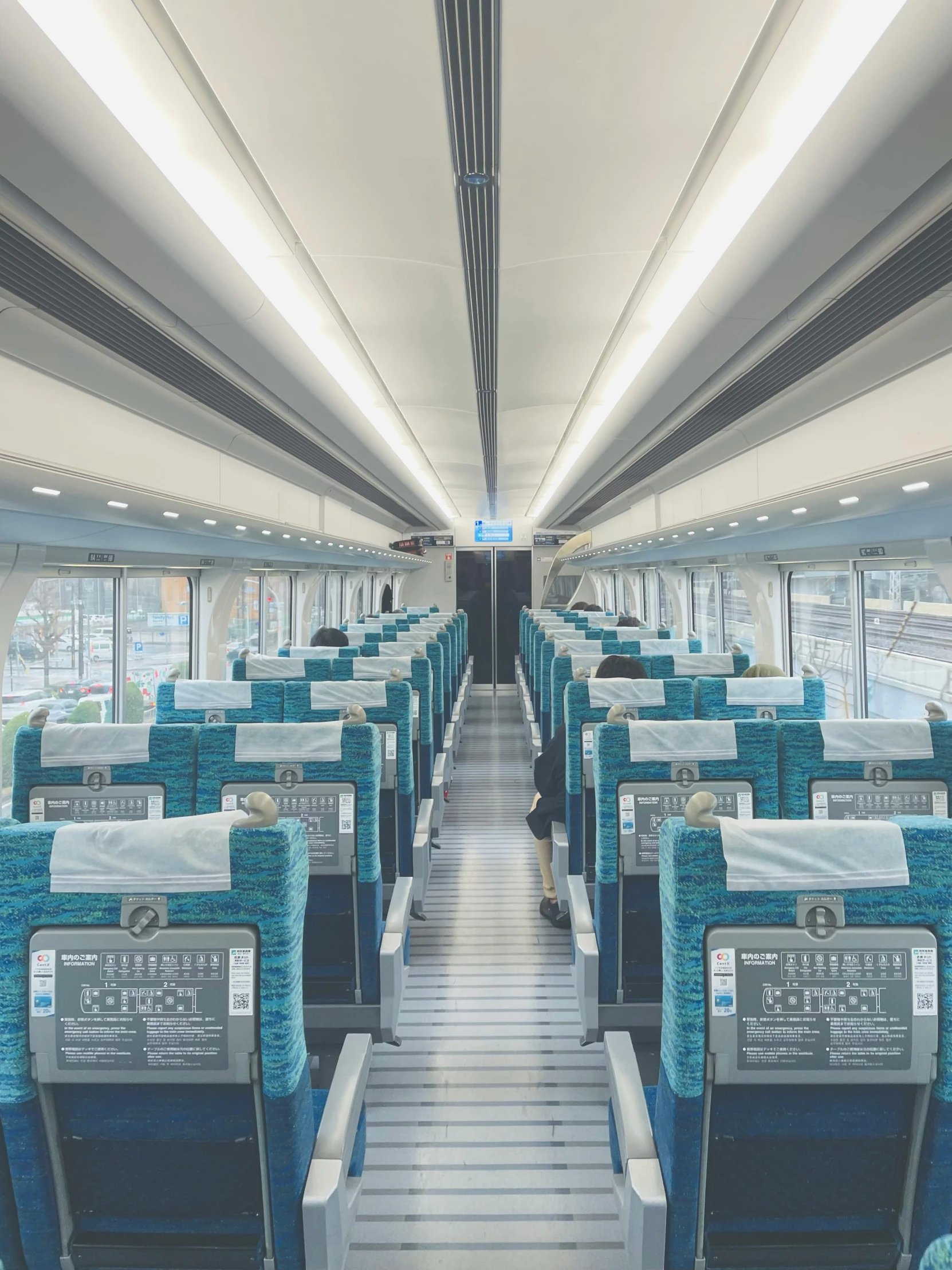 the view of a train car with lots of seats and a ceiling light