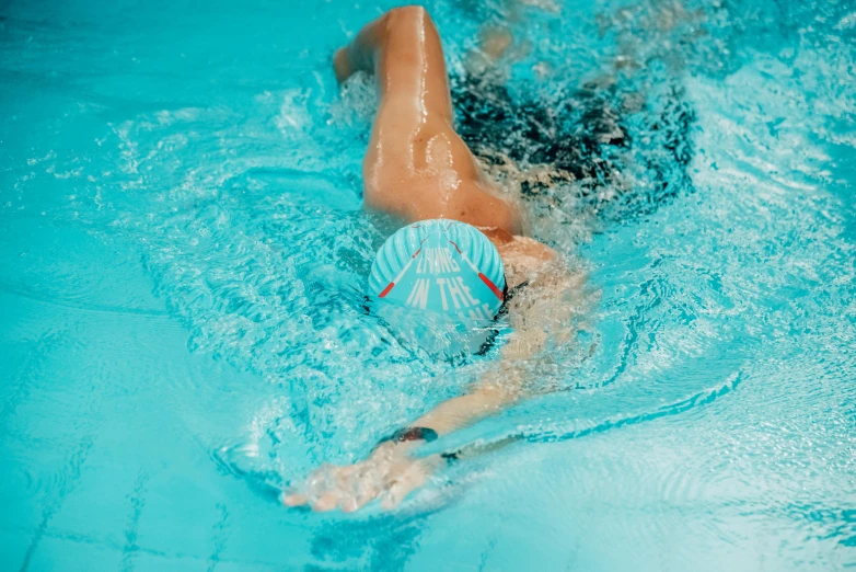 a woman swimming in a blue pool with  on