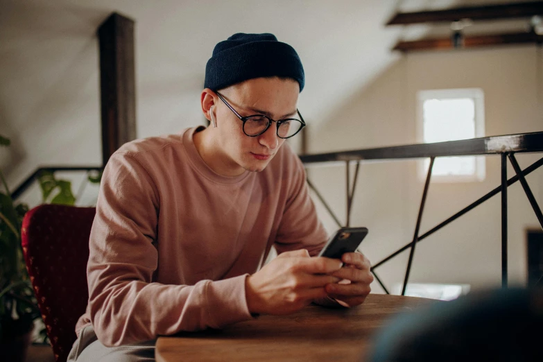 a person sitting at a table using a smart phone