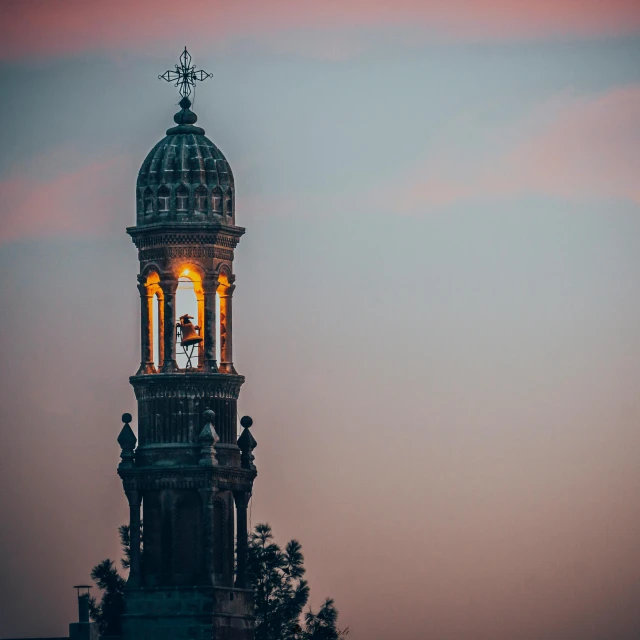 an architectural clock tower is shown illuminated at dusk