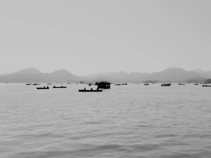 small boats on an empty lake by mountains