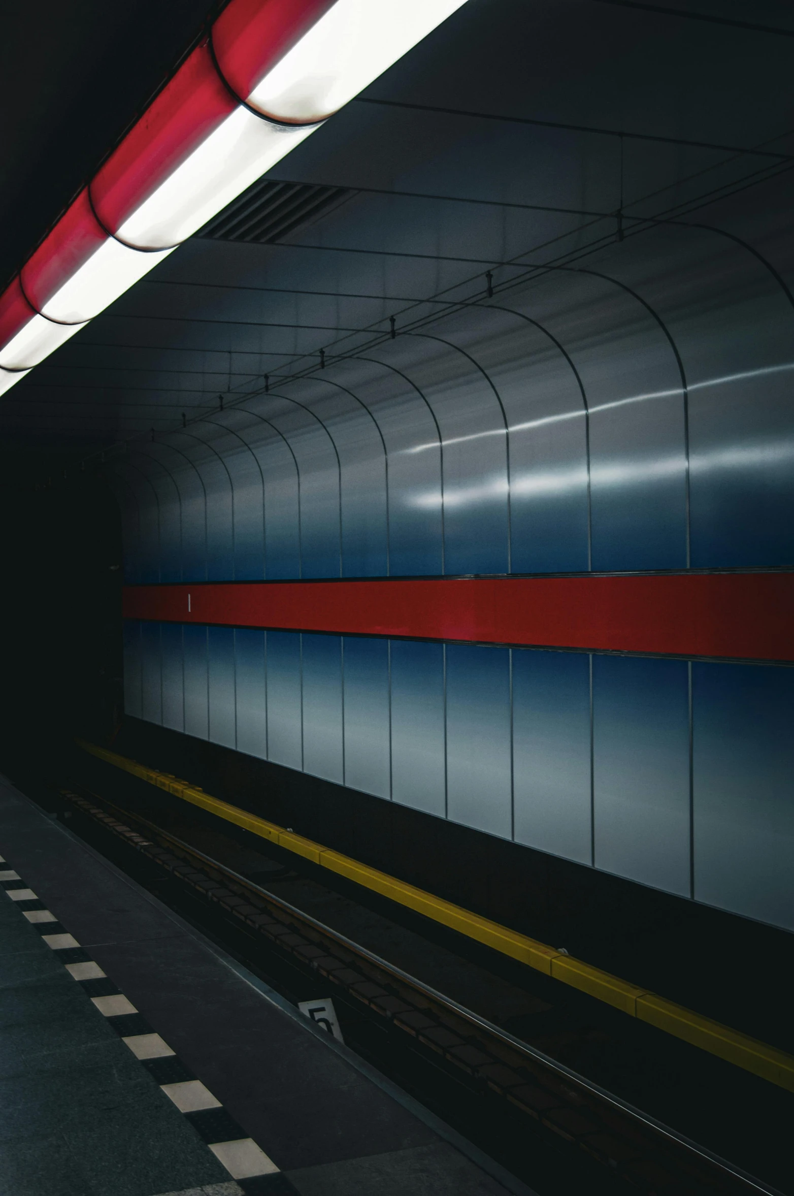 an empty subway station with a train traveling down the track