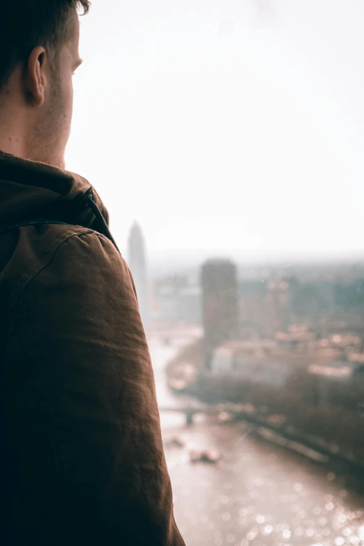 a man standing outside overlooking the city with a view of the river