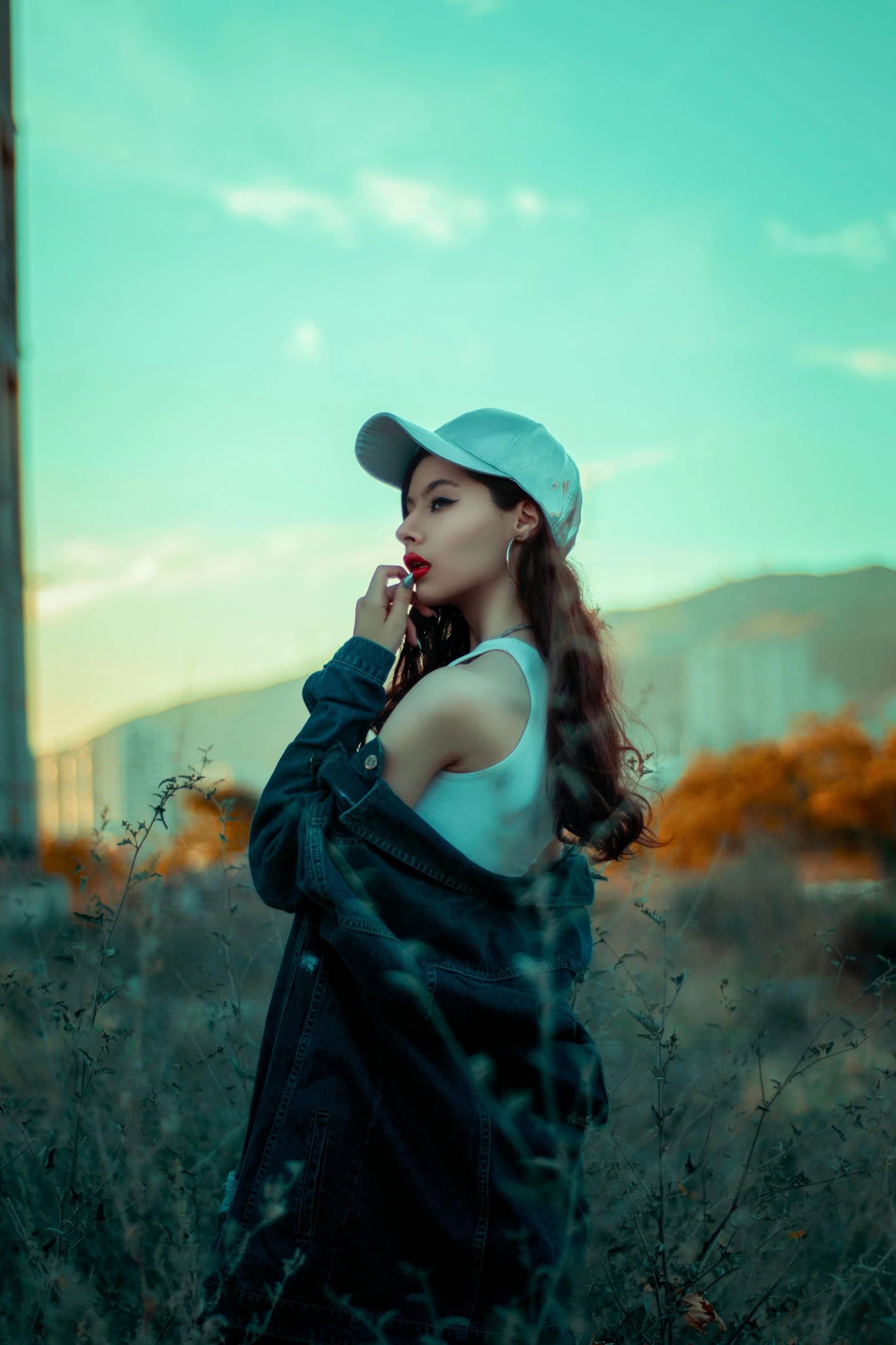 a woman standing outside while smoking a cigarette