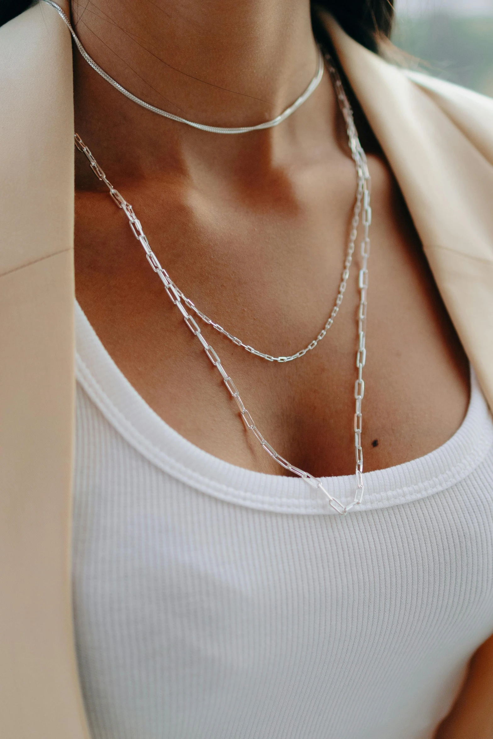 the model wears a long necklace with two chain