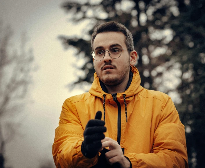 a man in a yellow jacket standing outside