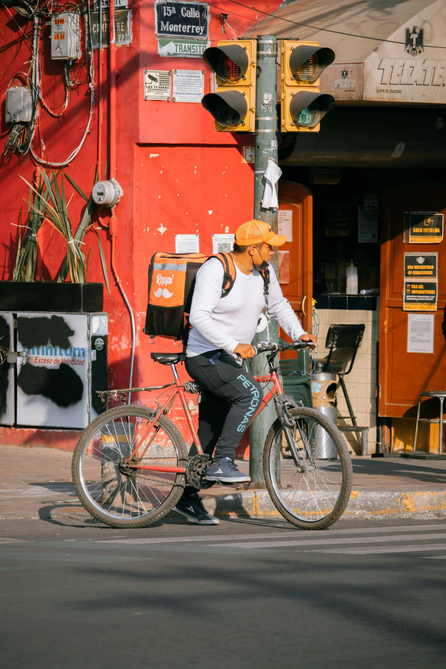 a man in a orange hat on a bicycle