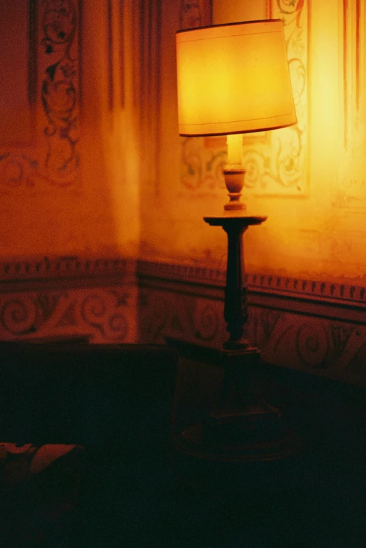 the lamp is on by a large painting in a room