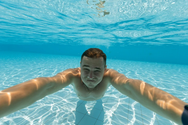 a man floating in water near a camera