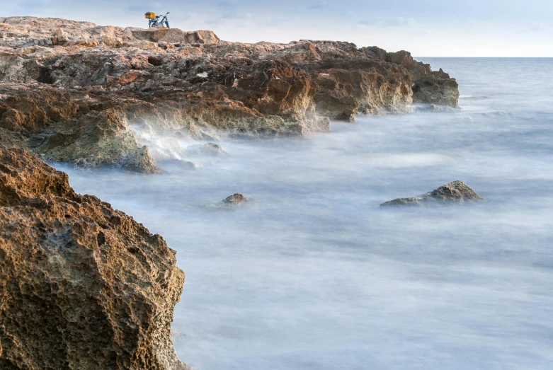 several people standing on a rocky cliff surrounded by fog