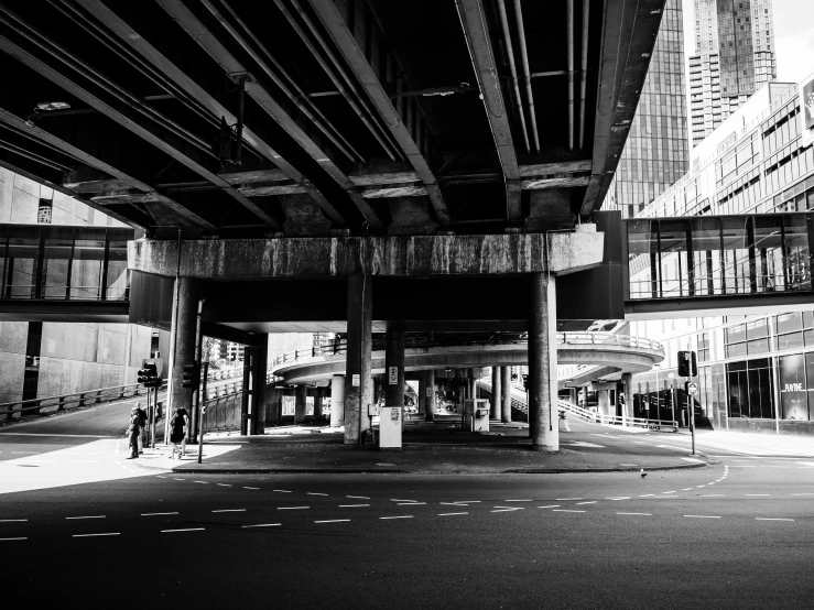 an empty city street and under - the - bridge in black and white