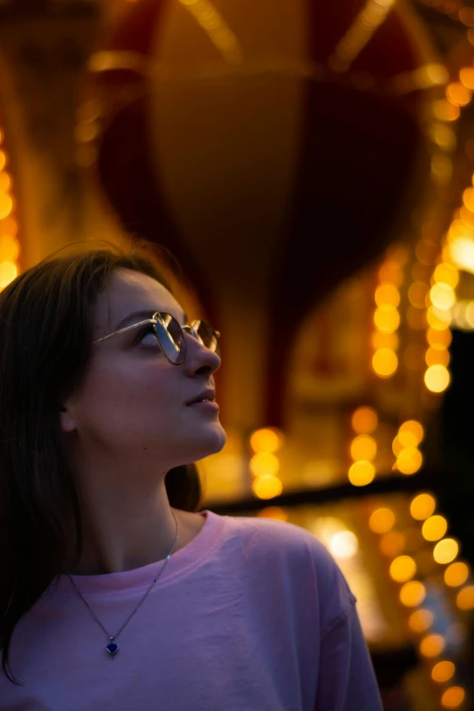 a woman is looking away from the light on the carnival ride