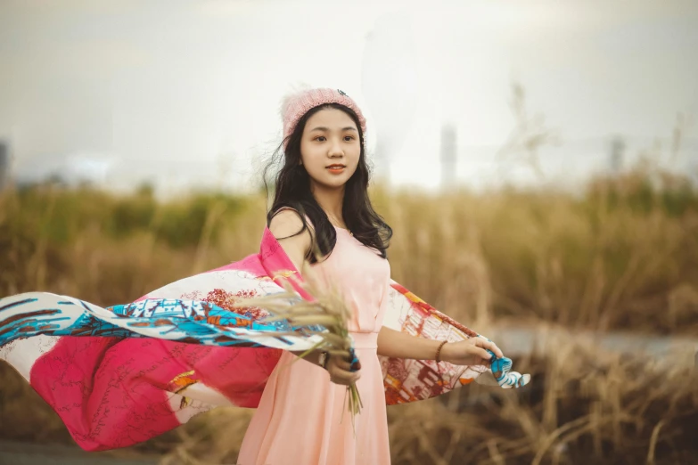 a woman with a long pink hat holding an umbrella