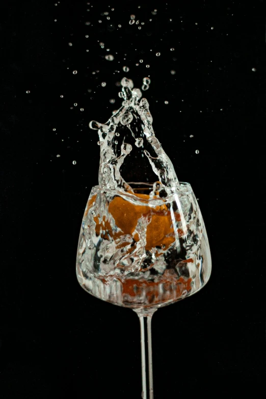 a liquid splash with some sort of orange and water floating out of it