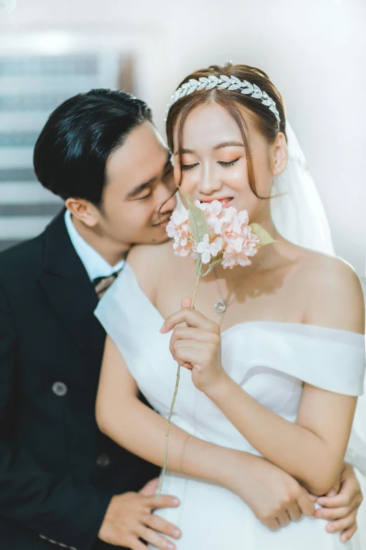 a bride and groom are hugging for the camera