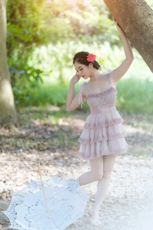 an asian woman in a pink dress is holding an umbrella