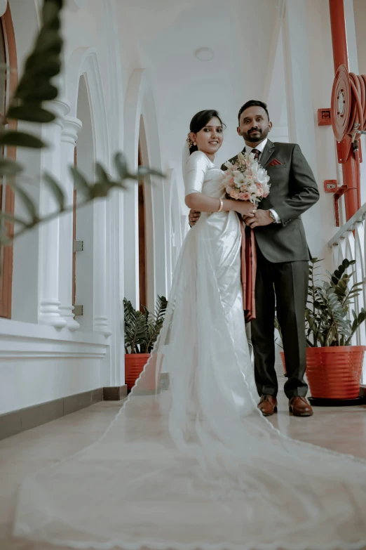 a newly wed couple posing together on the balcony of their home