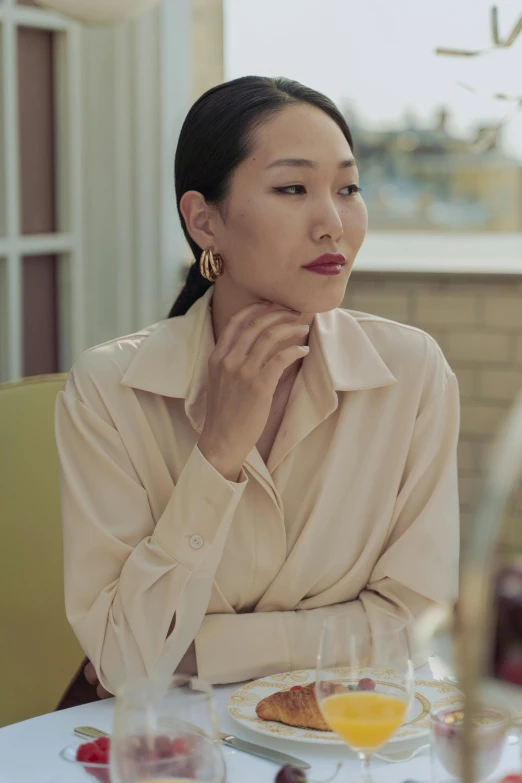 a woman in a pink shirt is sitting at a table