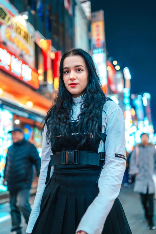 a woman standing in the street with a black dress on