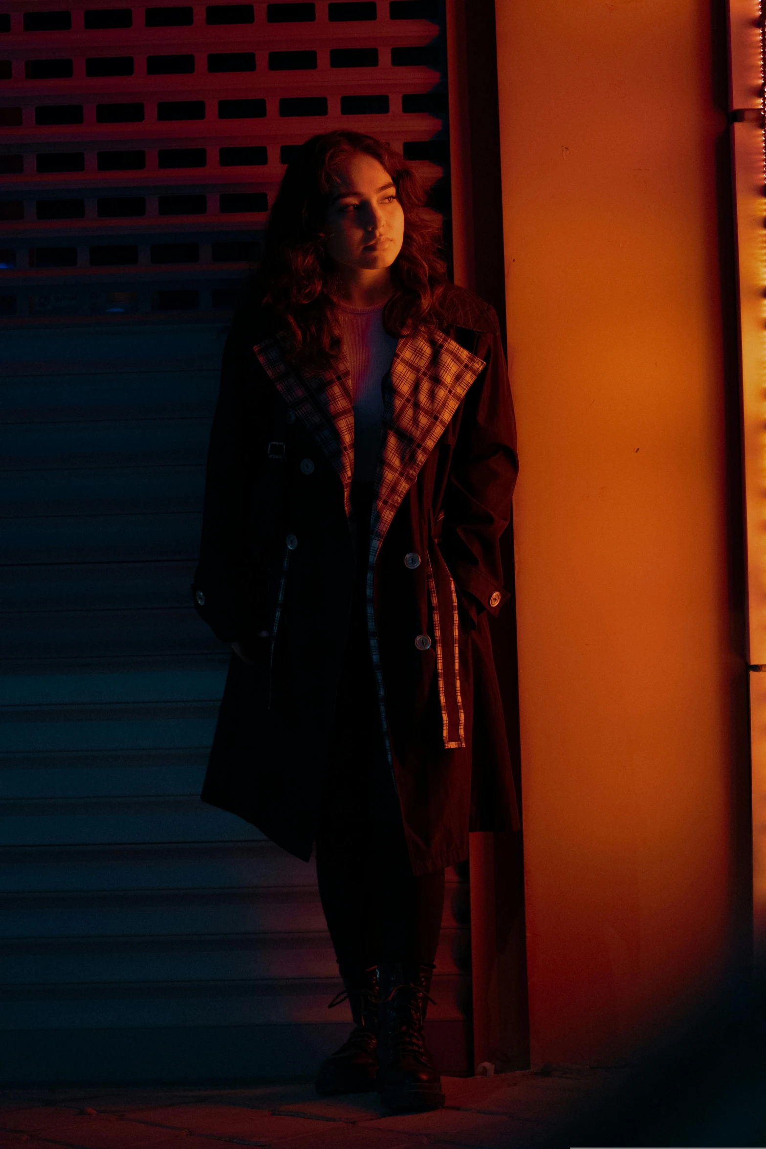 woman standing in dark, open space with glowing light at night