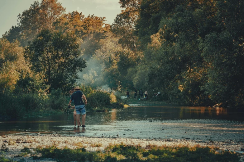 a man walks along the water in a forest