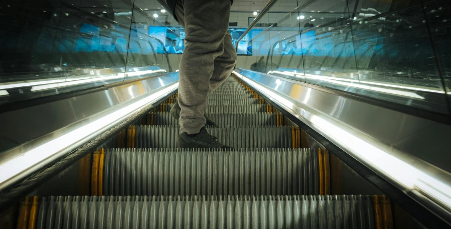 a person is walking down an escalator