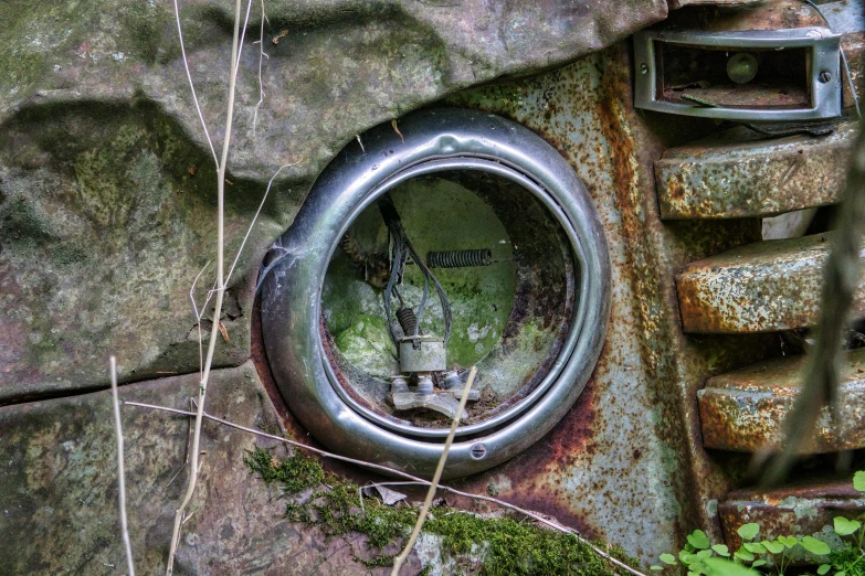 an old rusty round window with plants growing on it