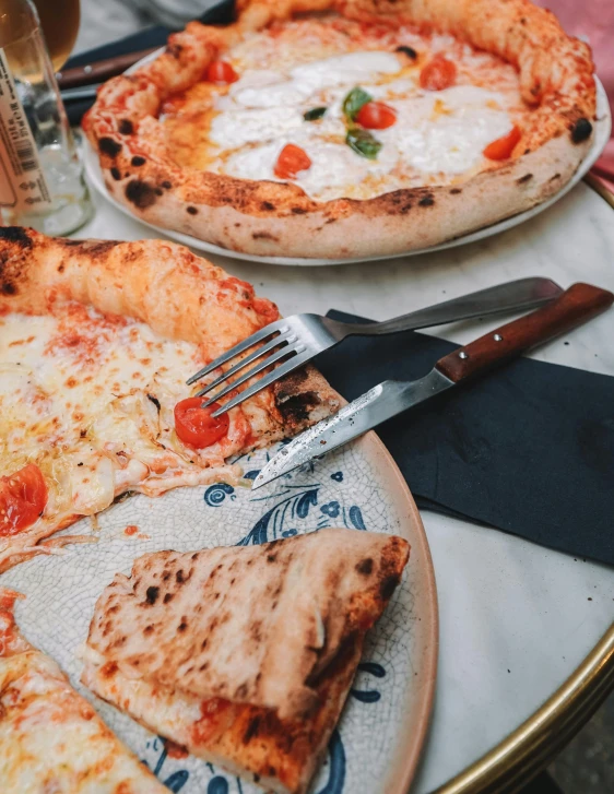 a pizza sitting on top of a table with a spatula and a pizza cutter